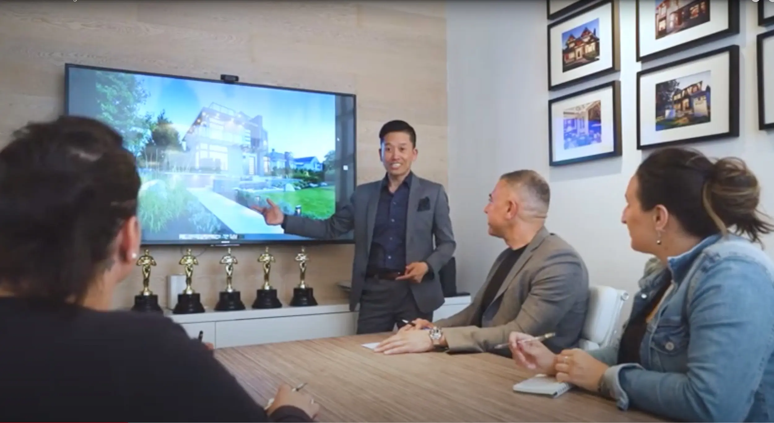 Eric Lee standing at a screen, presenting to three people around a meeting table